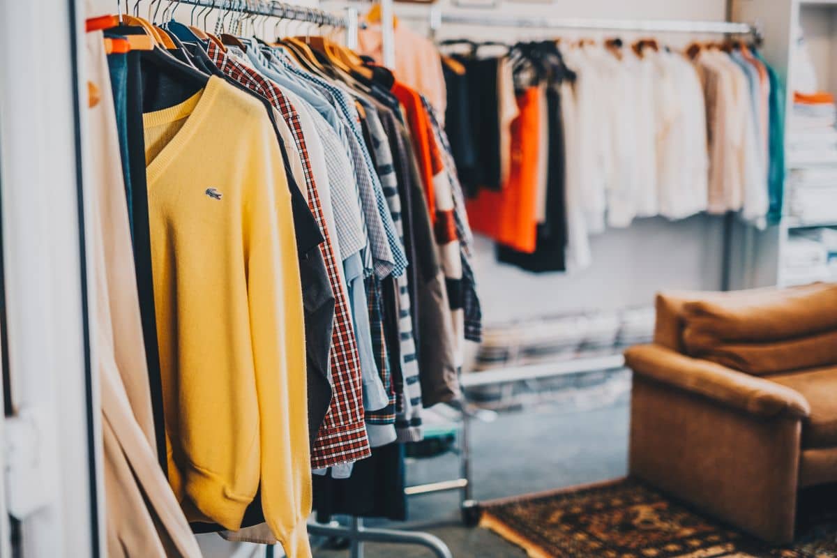 Second-Hand-Kleidung in Essen kaufen – Kleiderstangen mit Pullovern und Hemden
